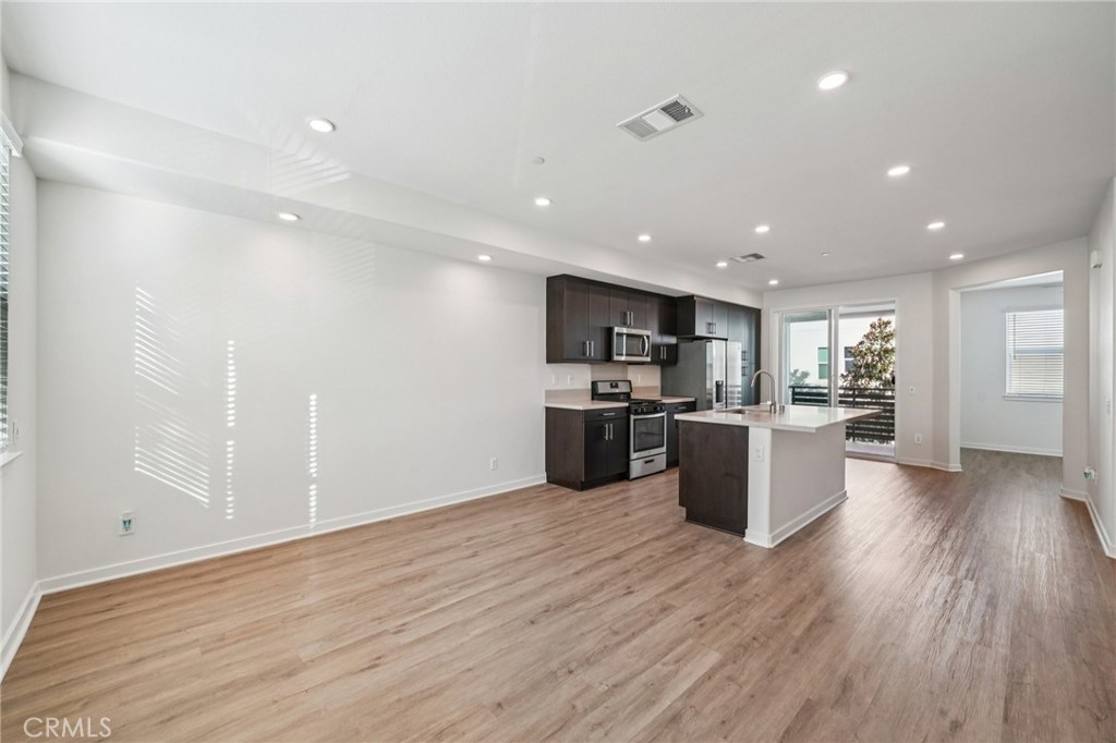 9422 Shade Place Rancho Cucamonga, CA 91730 - Photo 6 of 72 a kitchen with a sink wooden floor stainless steel appliances and cabinets