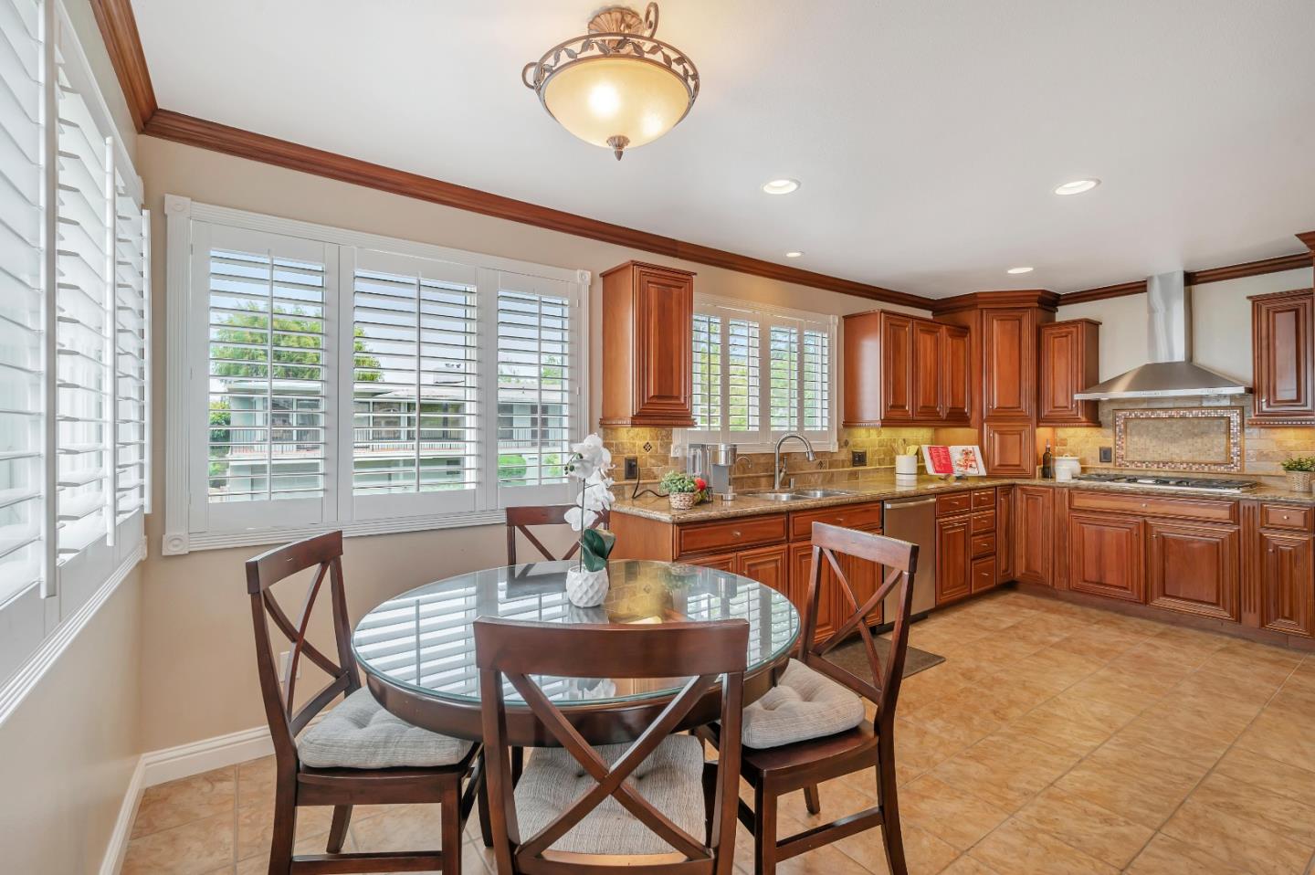 305 La Prenda Millbrae, CA 94030 - Photo 19 of 50 a open dining room with stainless steel appliances kitchen island granite countertop a table chairs and a refrigerator