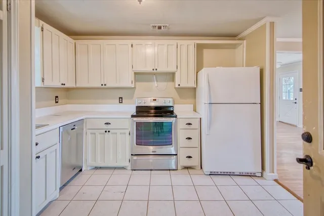 a kitchen with cabinets and a refrigerator