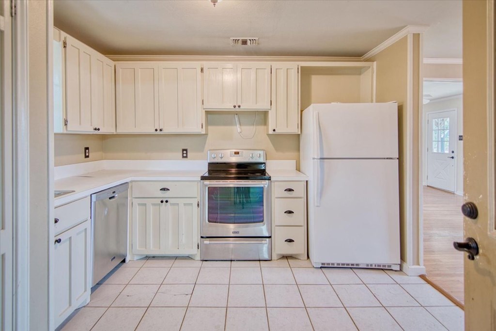 1013 Church Street Mason, TX 76856 - Photo 12 of 25 a kitchen with cabinets and a refrigerator