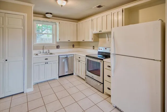 a kitchen with white cabinets and white appliances