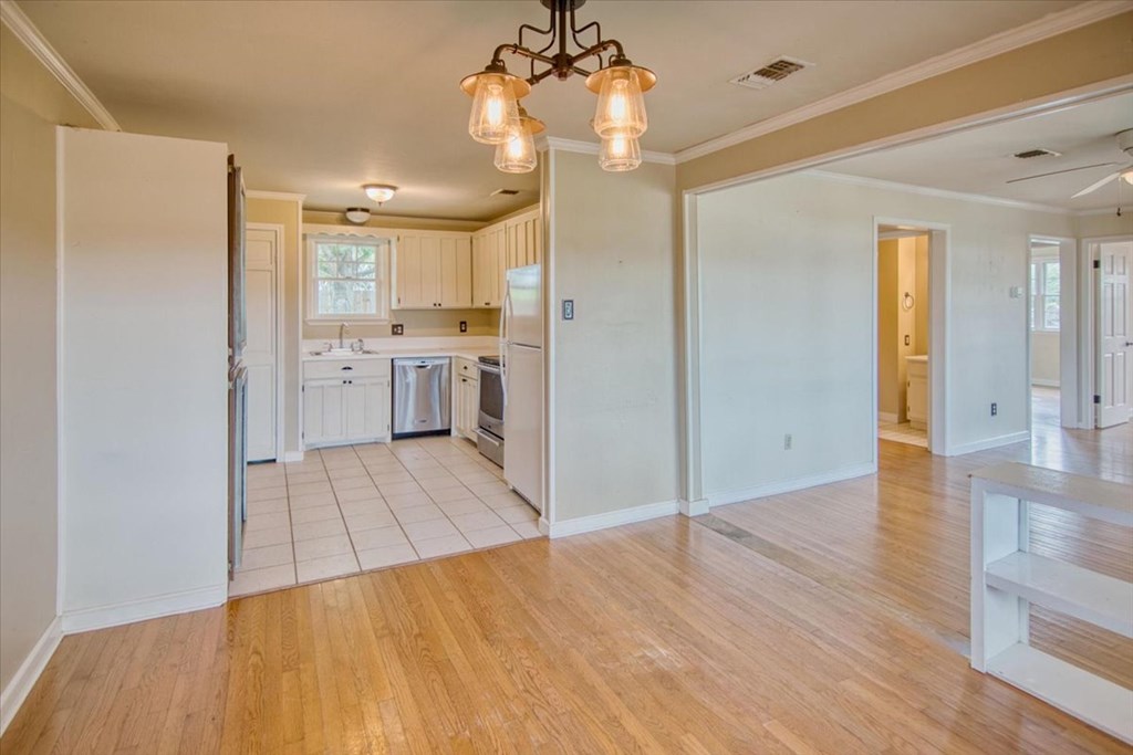 1013 Church Street Mason, TX 76856 - Photo 14 of 25 a open kitchen with a sink dishwasher a refrigerator and wooden floor