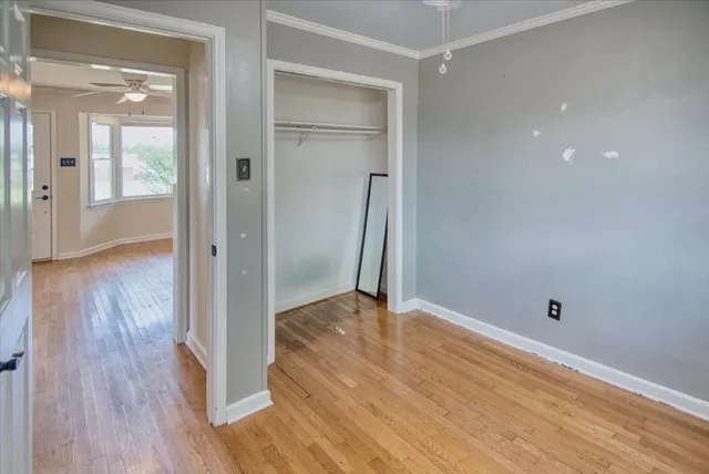 a view of empty room with wooden floor