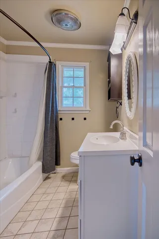 a bathroom with a sink and mirror with bathtub