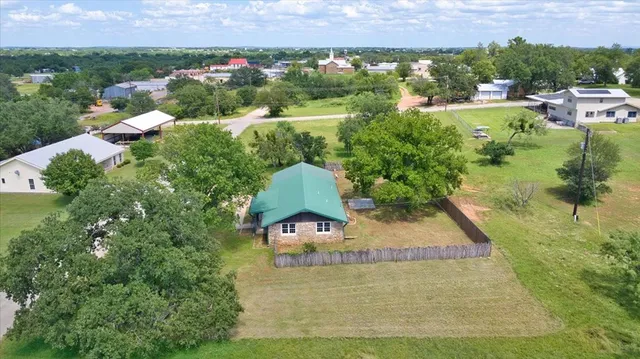 an aerial view of a house with a yard and lake view