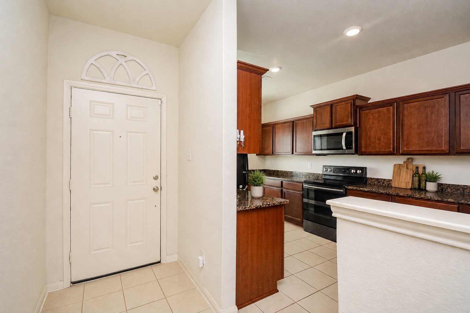 1322 Emerald Stone Drive Rosharon, TX 77583 - Photo 3 of 23 a kitchen with stainless steel appliances granite countertop a stove top oven a refrigerator a sink and dishwasher with white cabinets