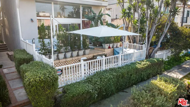a view of a patio with a table and chairs under an umbrella