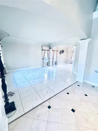 a view of a refrigerator in kitchen and an empty room
