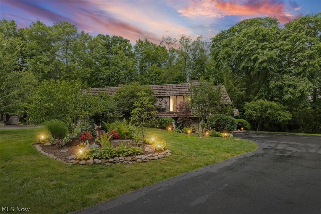 Asphalt driveway leading to Unit 107 with a shingled roof and brick exterior accents