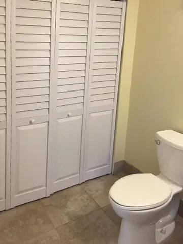 a white toilet sitting next to a white cabinet