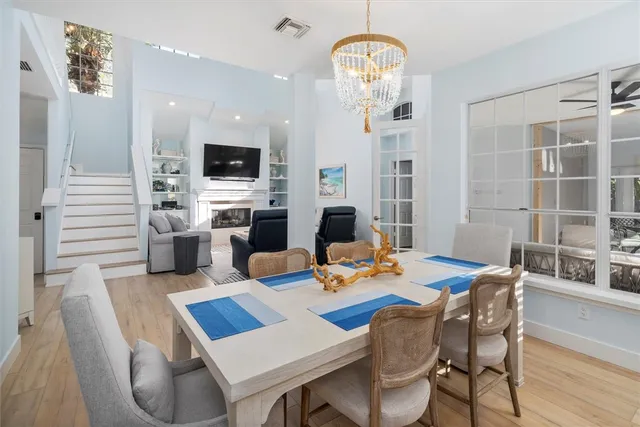 a view of a dining room with furniture a chandelier and wooden floor