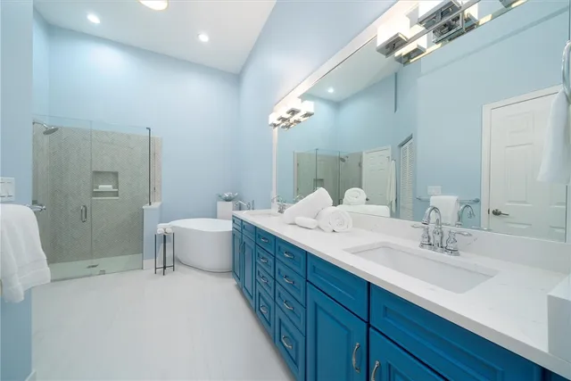 a spacious bathroom with a double vanity sink mirror and a bathtub