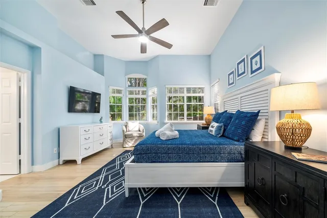 a bed sitting in a spacious bedroom next to a window