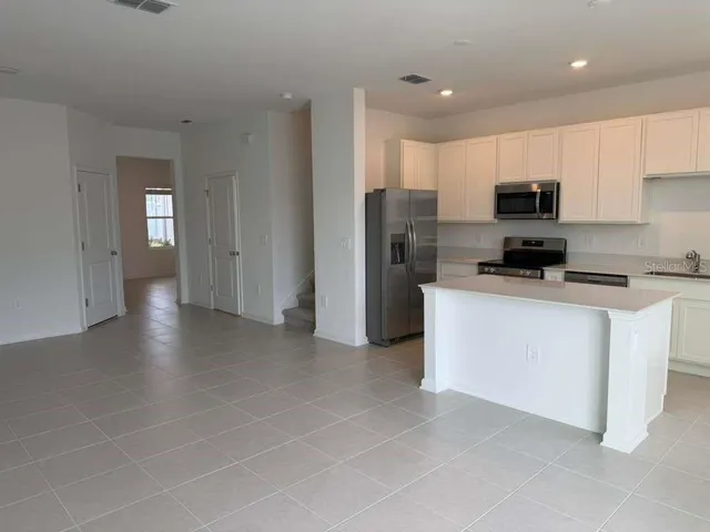 a kitchen with stainless steel appliances a refrigerator sink and microwave