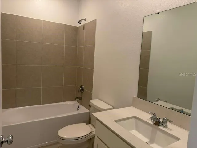 a bathroom with a granite countertop sink a mirror and a shower