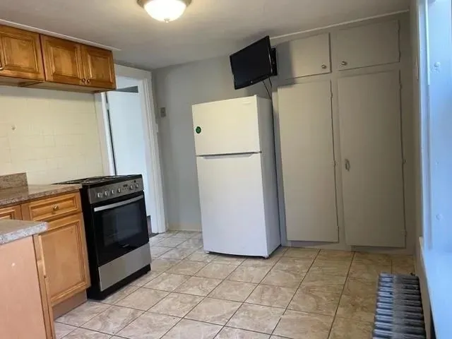 a kitchen with a refrigerator and a stove top oven
