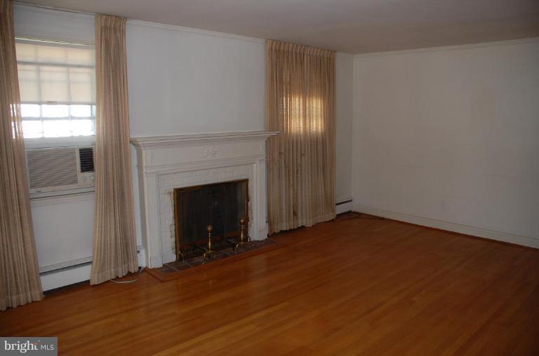 3105 Bonnie Road Baltimore, MD 21209 - Photo 3 of 10 a view of an empty room with wooden floor and a window