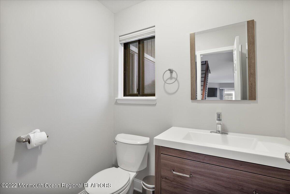 5 Island View Way, Unit 10 Sea Bright, NJ 07760 - Photo 19 of 30 a bathroom with a toilet a sink a mirror and vanity