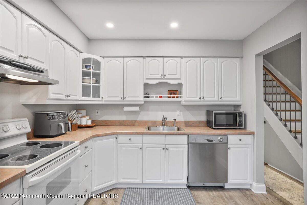 5 Island View Way, Unit 10 Sea Bright, NJ 07760 - Photo 21 of 30 a kitchen with granite countertop a sink stainless steel appliances and cabinets