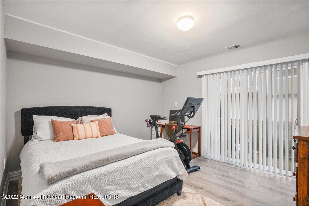 5 Island View Way, Unit 10 Sea Bright, NJ 07760 - Photo 9 of 30 a bedroom with a bed and a lamp