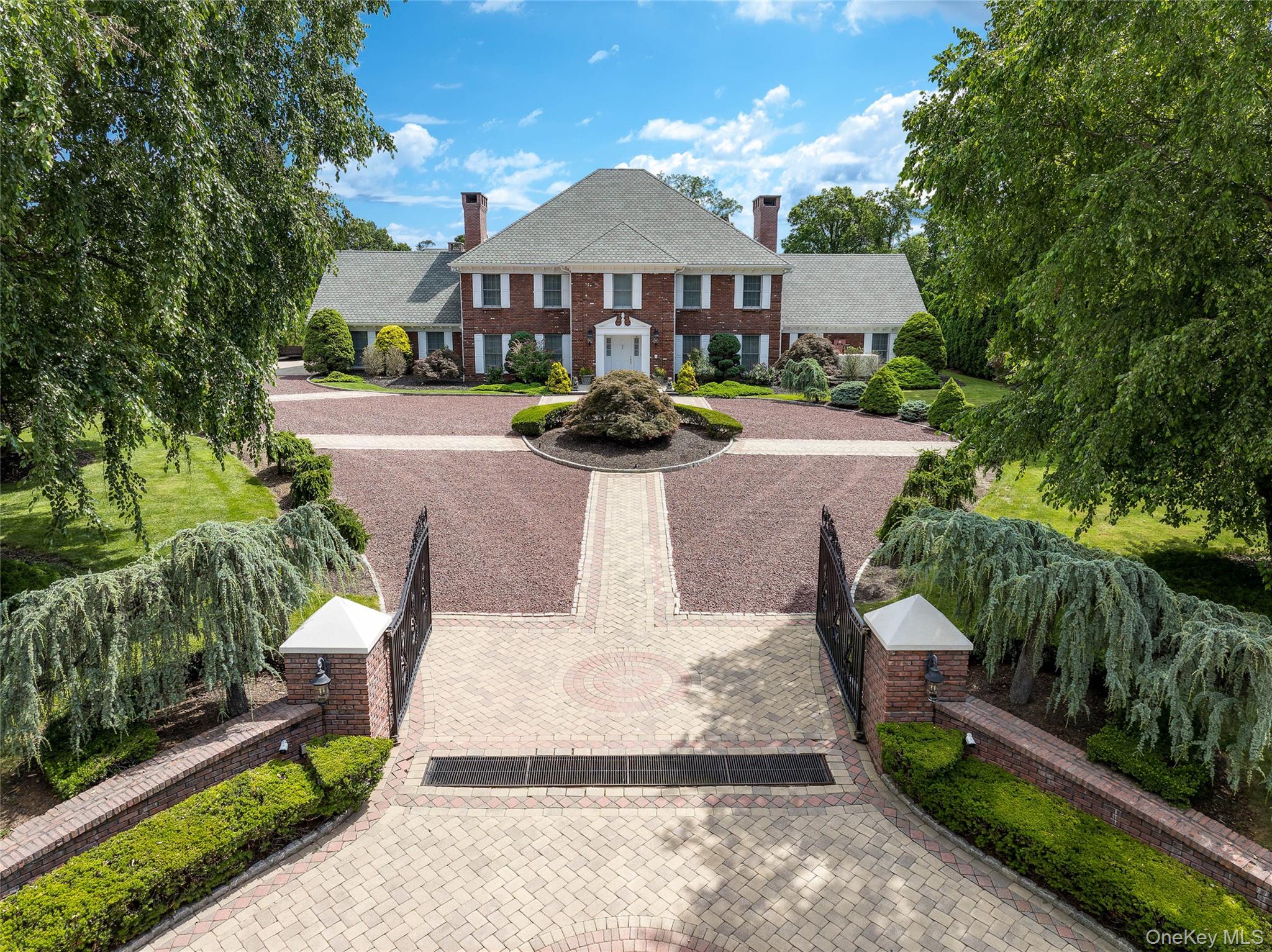 Iconic Georgian Colonial in the Murray Hill Estate Section in Scarsdale features circular 3-tone driveway, classic details, two chimneys, brick siding, white shutters