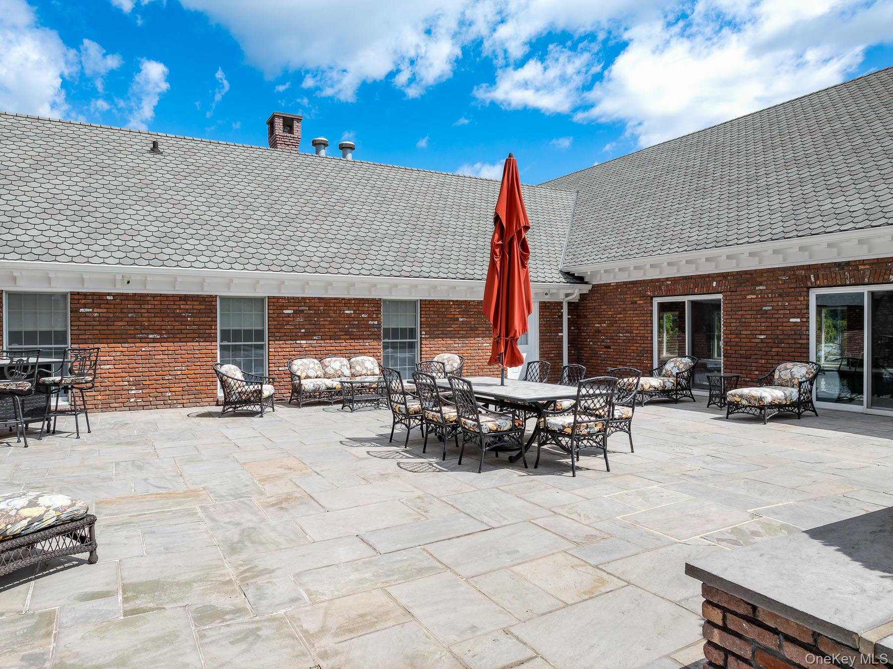 109 Mamaroneck Road Scarsdale, NY 10583 - Photo 17 of 50 View of courtyard patio featuring outdoor dining, lounging, entertaining space, sliders to indoor pool and door to spa room and full bathroom