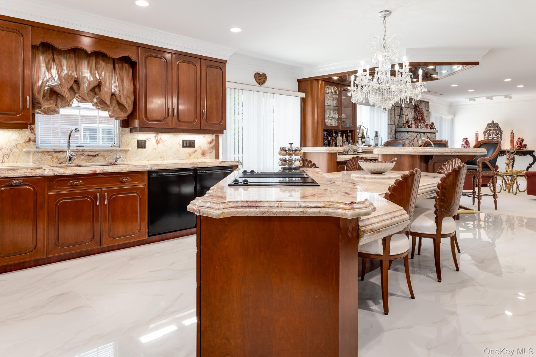 109 Mamaroneck Road Scarsdale, NY 10583 - Photo 28 of 50 Kitchen with crown molding, a kitchen breakfast bar, tasteful backsplash, a chandelier, and light like-marble finish flooring