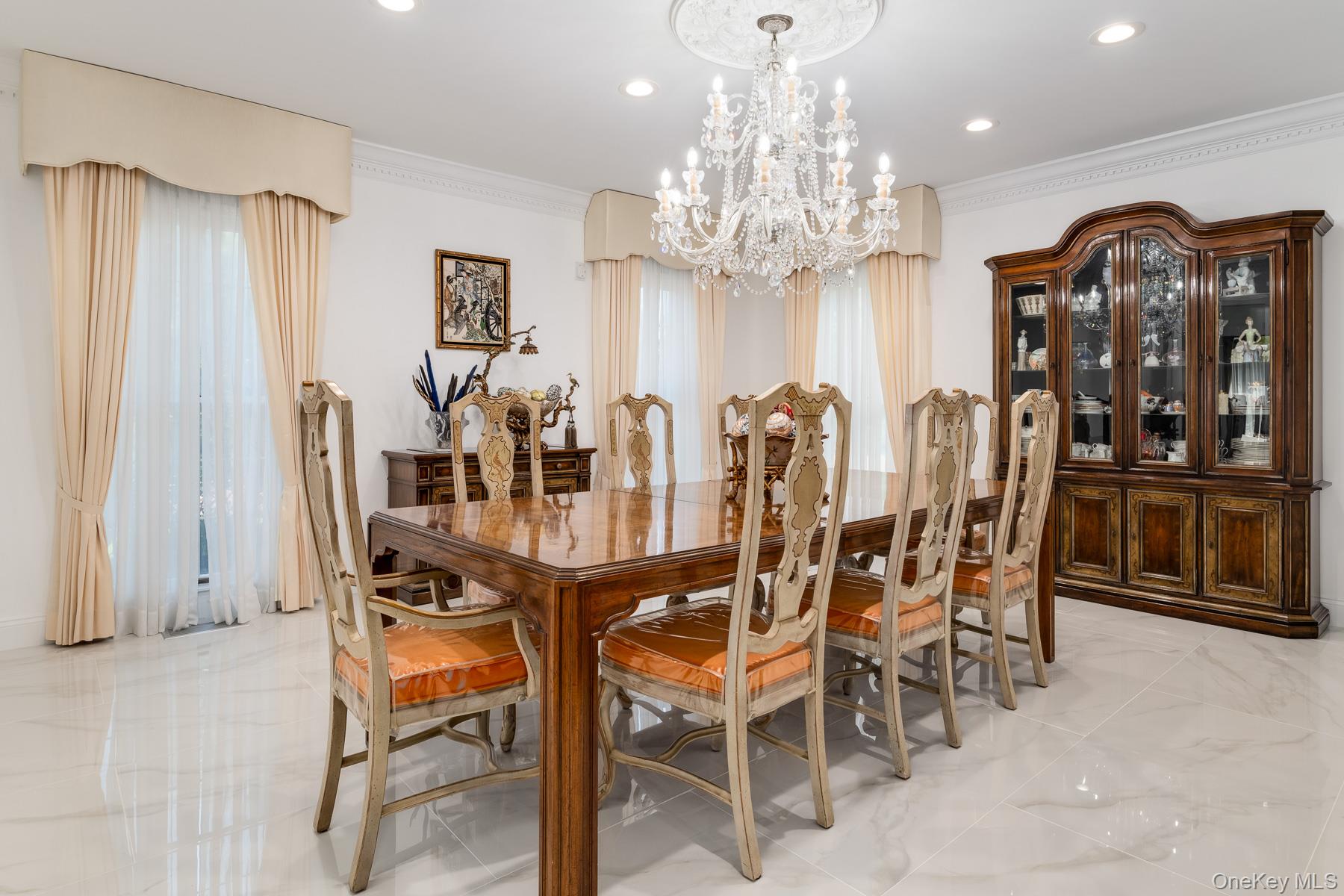 109 Mamaroneck Road Scarsdale, NY 10583 - Photo 33 of 50 Elegant dining area can fit up to 16 people with a Strauss & Swarvorski crystal chandelier, Greek dentil crown molding, new white like-marble floors, and recessed lighting on dimmers