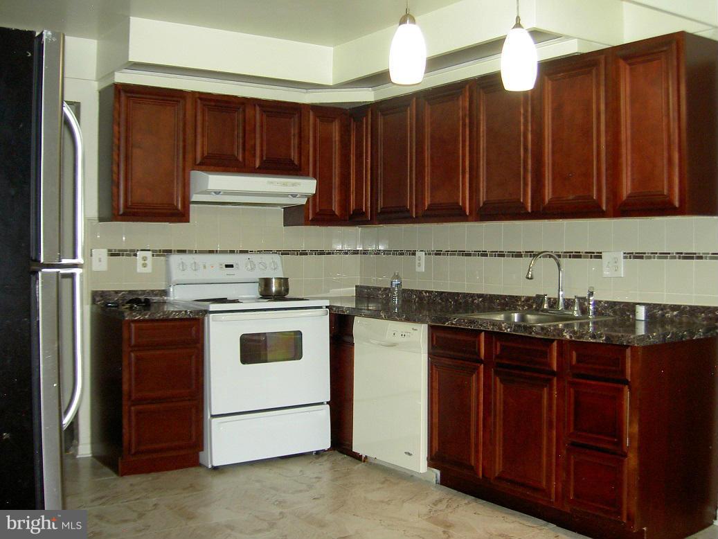 4510 Maryknoll Road Baltimore, MD 21208 - Photo 14 of 30 a kitchen with wooden cabinets and a stove top oven