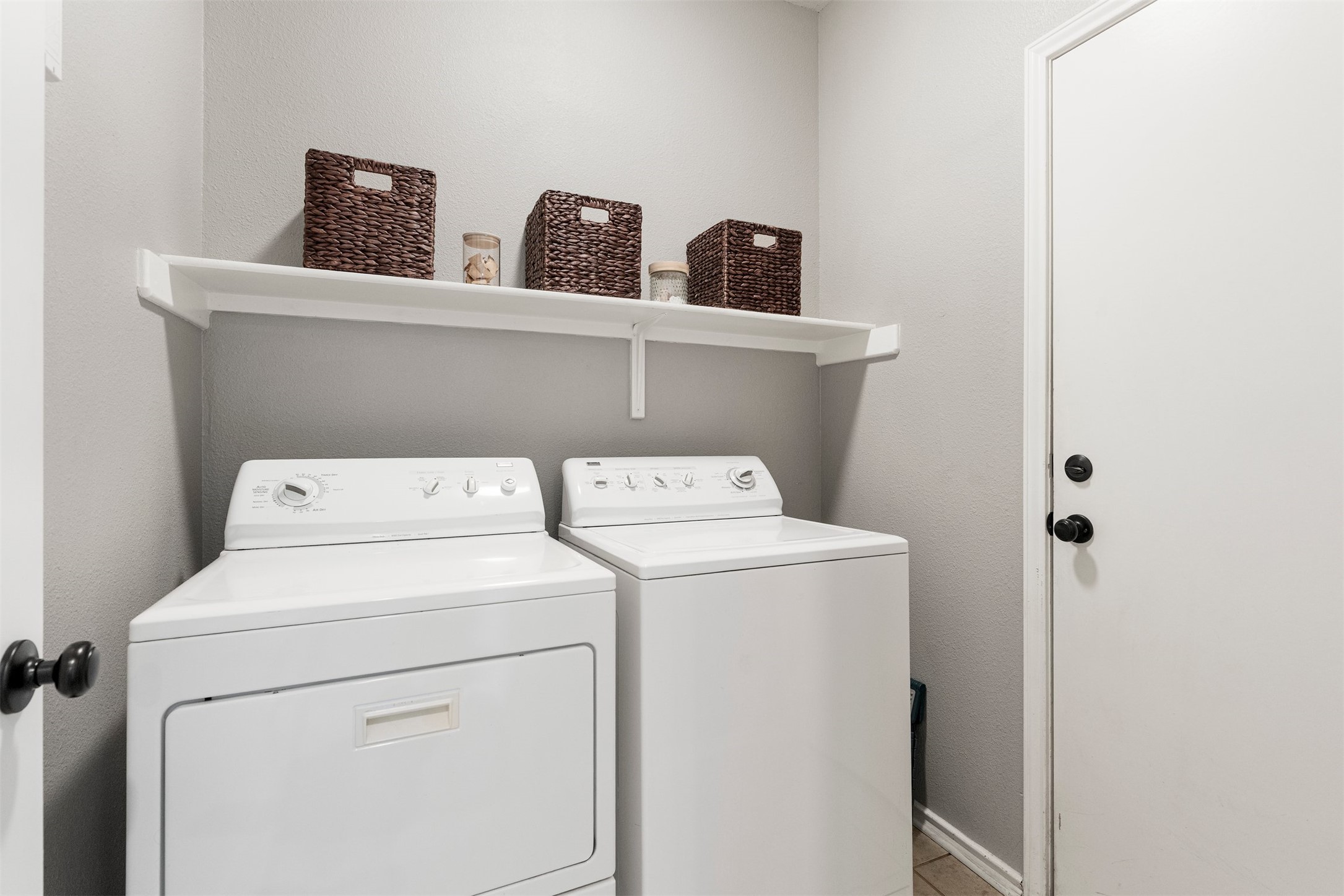 7009 Wandering Oak Road Austin, TX 78749 - Photo 25 of 36 Dedicated indoor laundry room with upper shelving offers convenient storage for detergents and household essentials right near the garage entry door