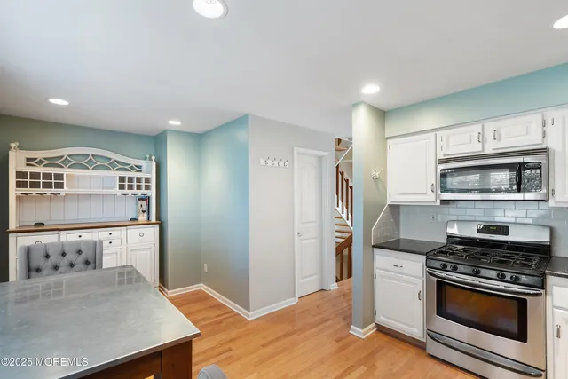 a kitchen with stainless steel appliances granite countertop a stove a refrigerator and a cabinets