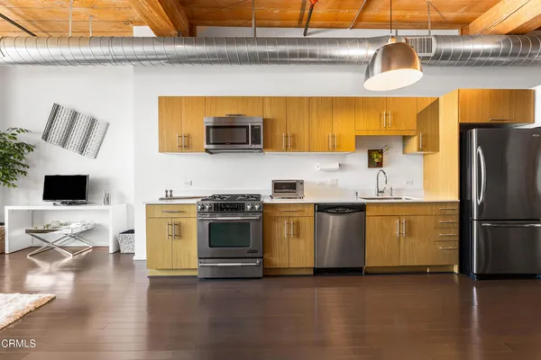 a kitchen with stainless steel appliances a stove a sink and white cabinets