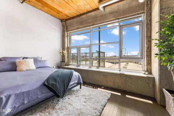 a bedroom with a bed and a large window