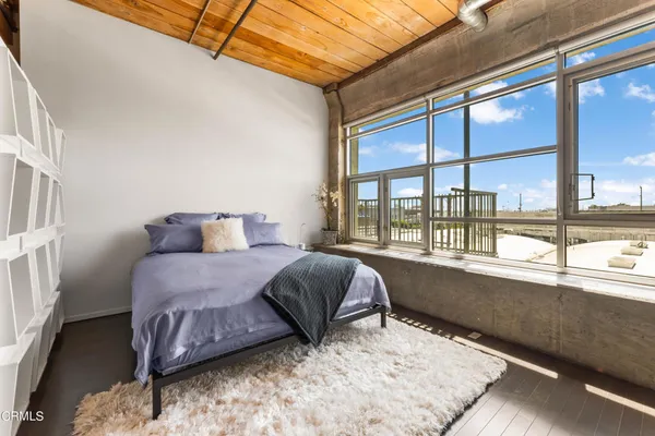 a bedroom with a bed and a large window
