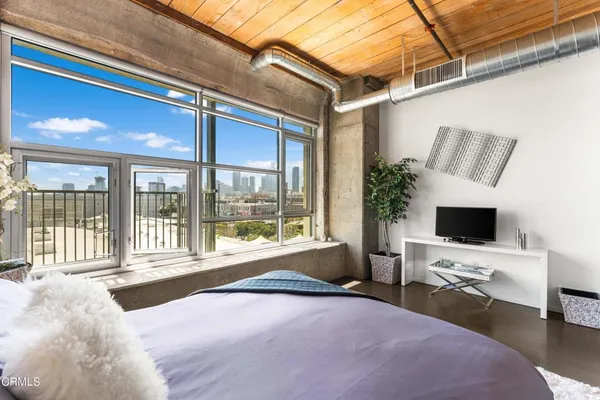 a bedroom with a bed and large window with outer view