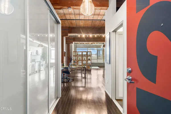 a view of a hallway with wooden floor fireplace and living room