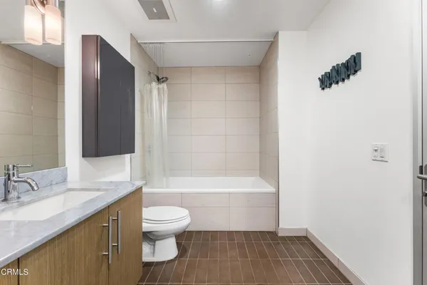 a bathroom with a granite countertop sink toilet a mirror and shower
