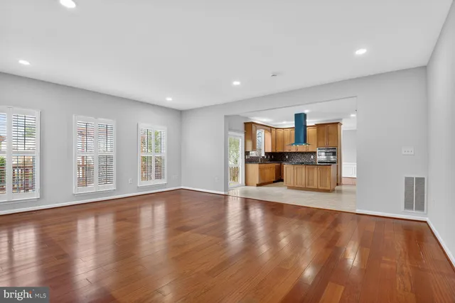 a view of empty room with wooden floor and windows