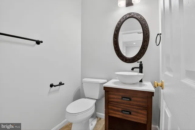 a bathroom with a sink a toilet and a mirror
