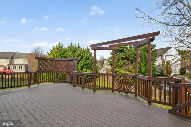 a view of a deck with wooden floor and fence with a large tree