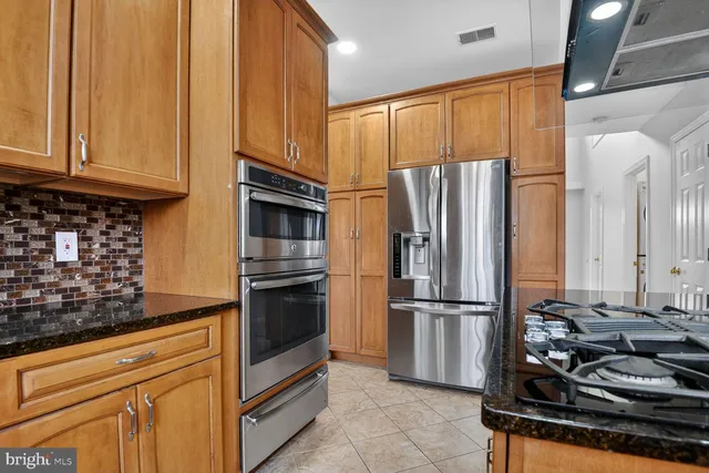 a kitchen with stainless steel appliances granite countertop a refrigerator stove and sink