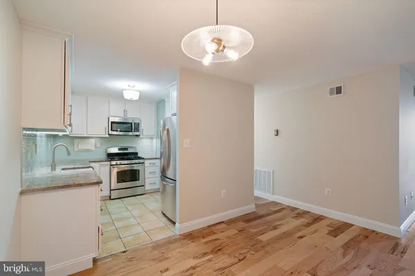 a kitchen with stainless steel appliances granite countertop a refrigerator sink and stove
