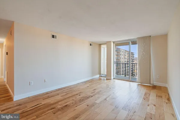 a view of a room with wooden floor and a bathroom