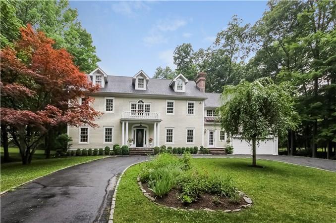 a view of a white house with a big yard and large tree
