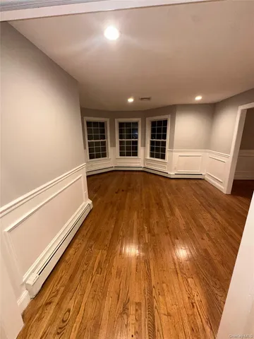 en empty room with wooden floor and windows
