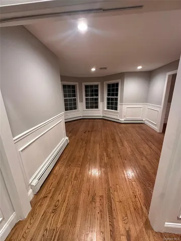 a view of empty room with wooden floor and window
