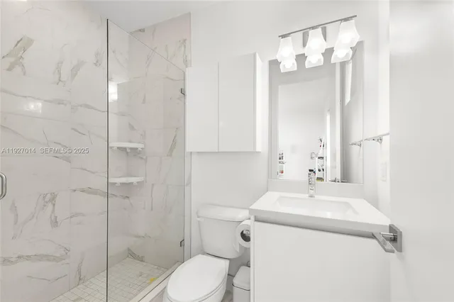 a large white kitchen with kitchen island a sink and a large window