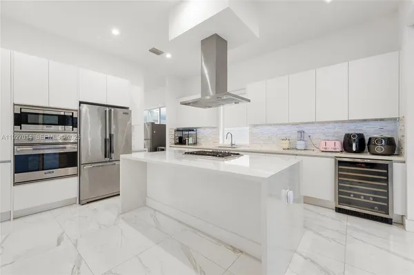 a kitchen with stainless steel appliances granite countertop a refrigerator sink and stove