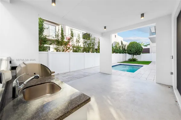 a large kitchen with stainless steel appliances a stove a sink and a refrigerator