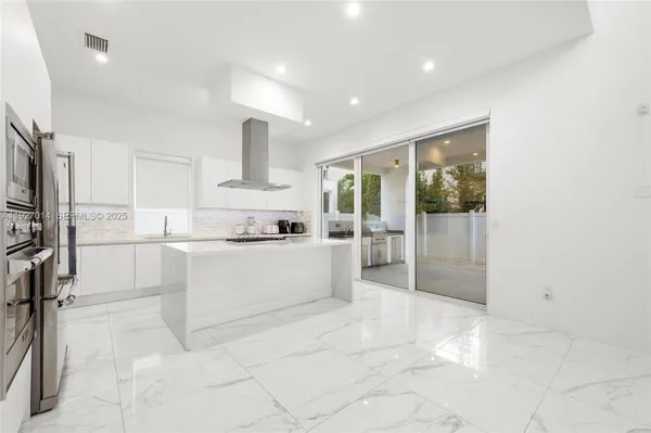 a large white kitchen with cabinets